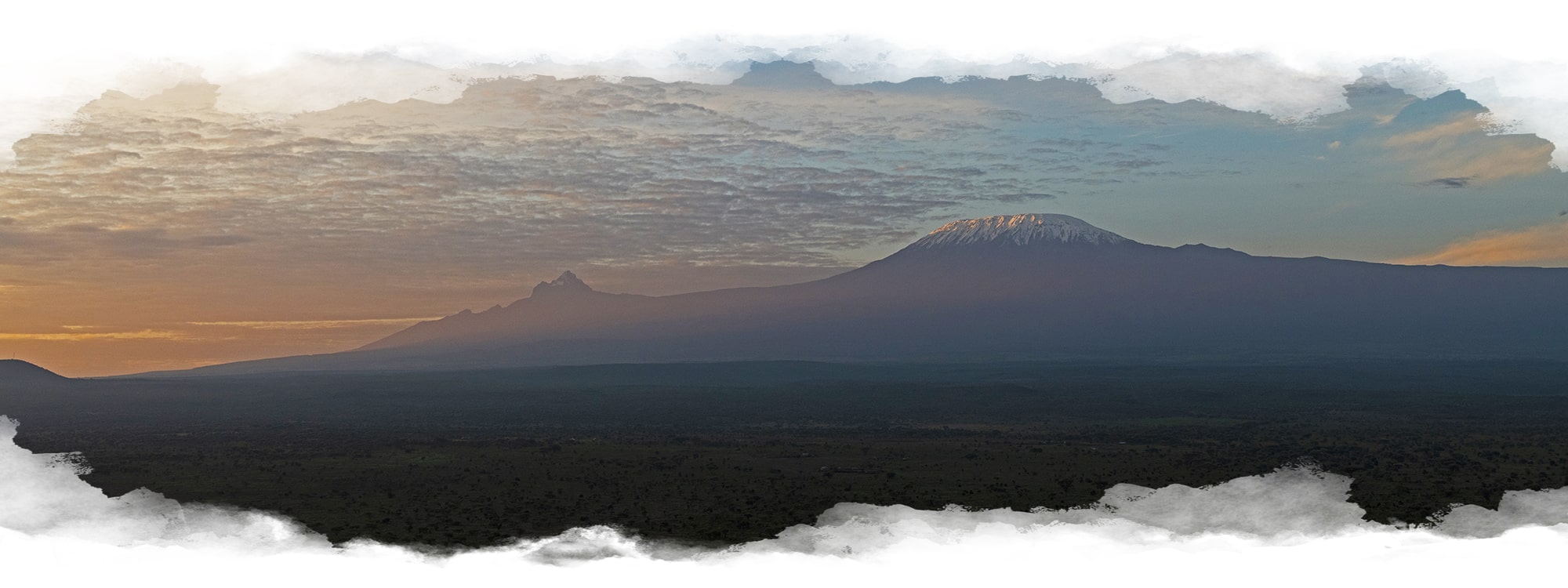 Image of sun rays lighting up Mount Kilimanjaro behind a green landscape