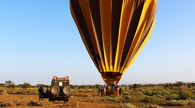 Image of balloon deflating and a land cruiser in front of it to pick up the guests